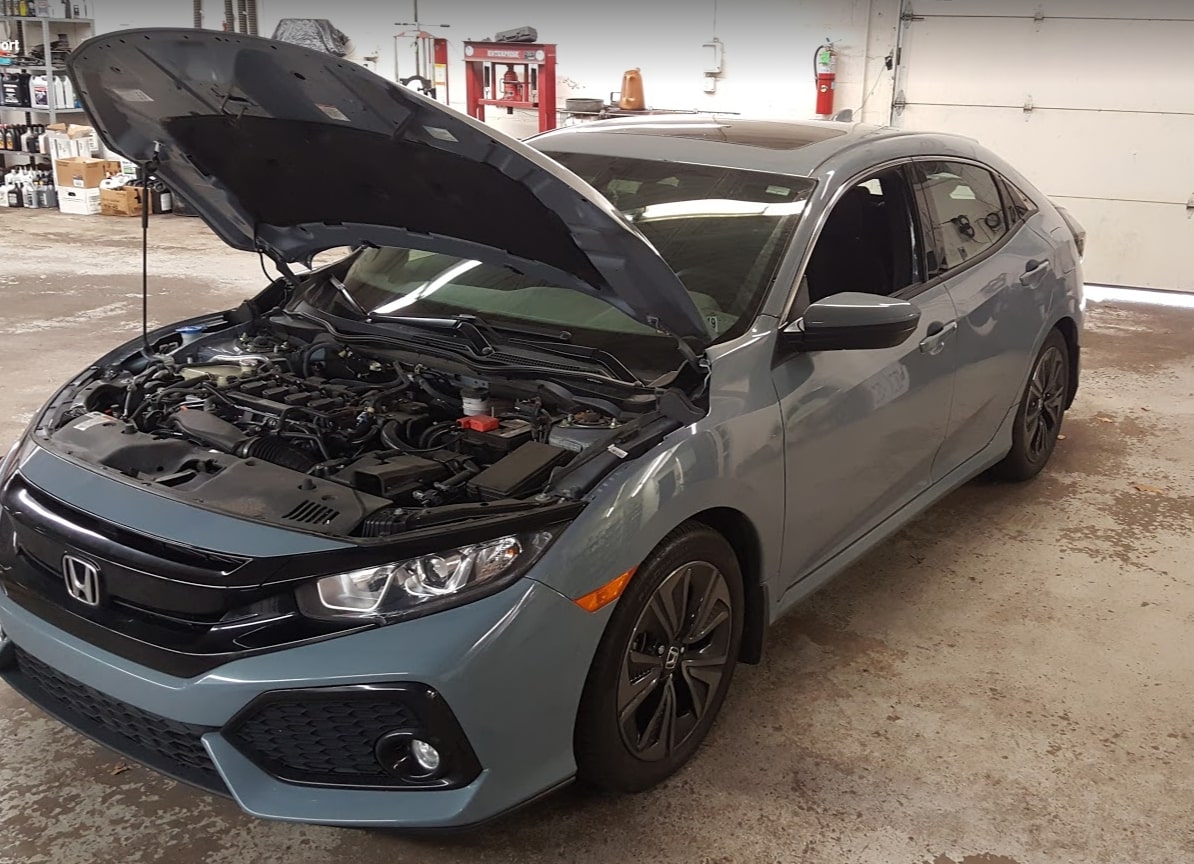 The front panel of a new car opened, revealing the engine components underneath